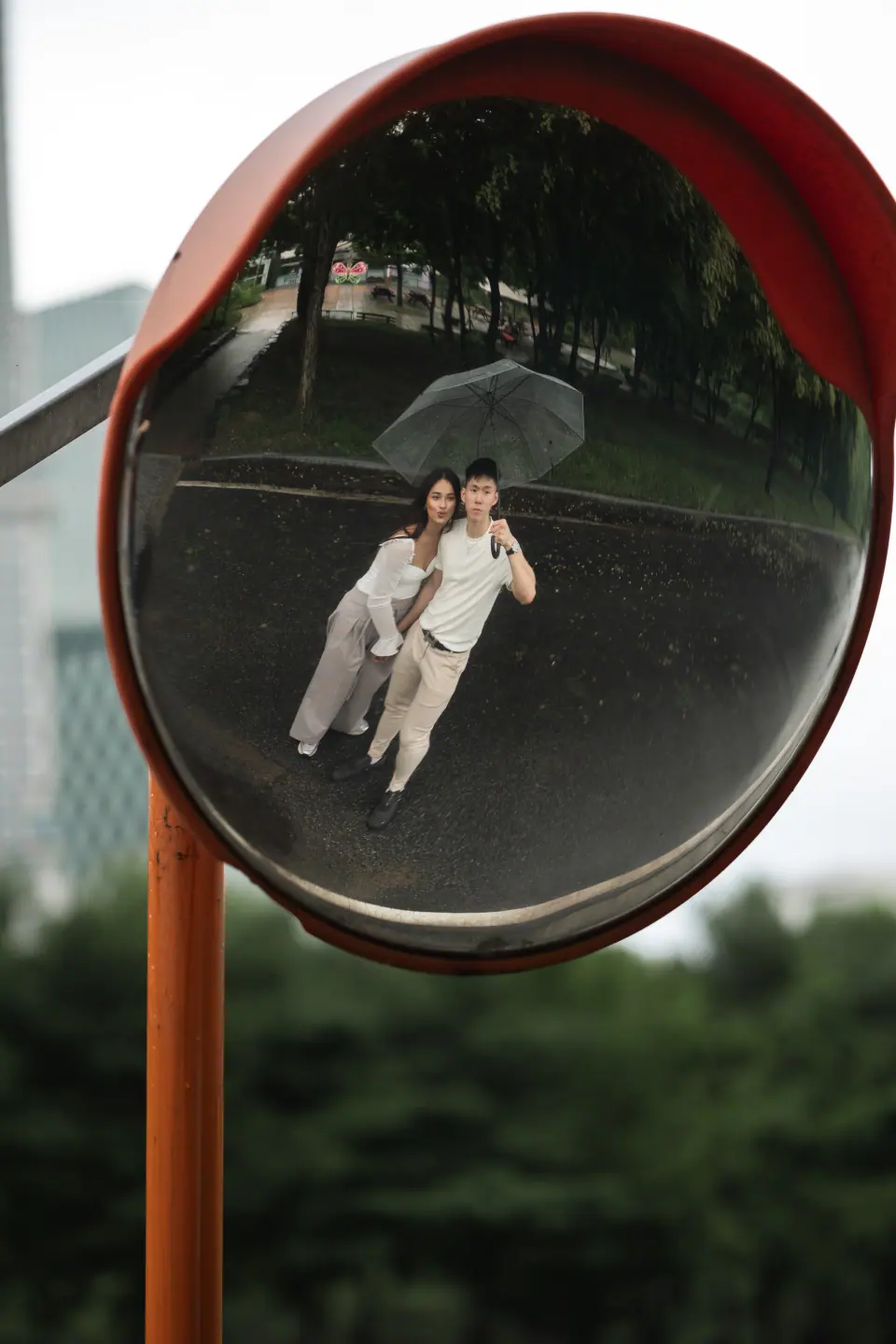 A couple reflected in a round traffic mirror