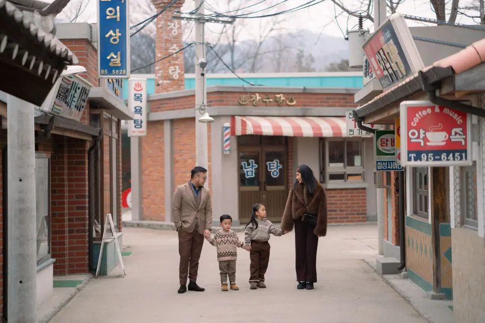 A family walking down a street of old shop signs